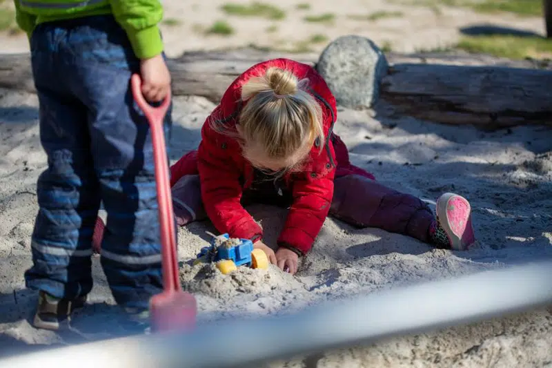 Børn der leger i sandkasse