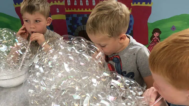 Børn puster bobler i mælk