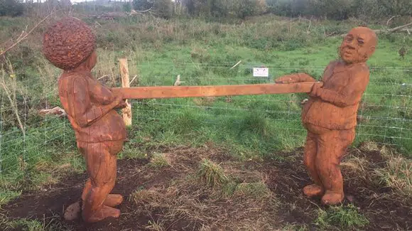 et par statuer af mennesker i tøj, der holder en pind