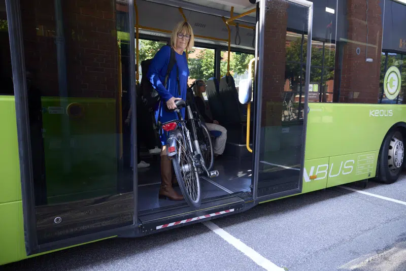 Kvinde tager cykel med i bussen