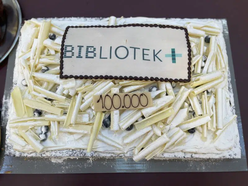 Kage med BIBLIOTEK+ og 100.000 i glasuren