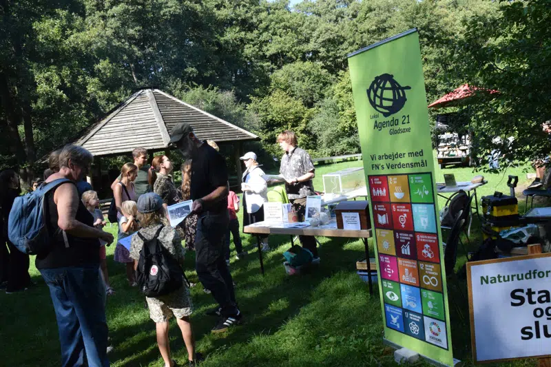 Borgere i forskellige aldre står omkring en bod fra foreningen Lokal Agenda 21.