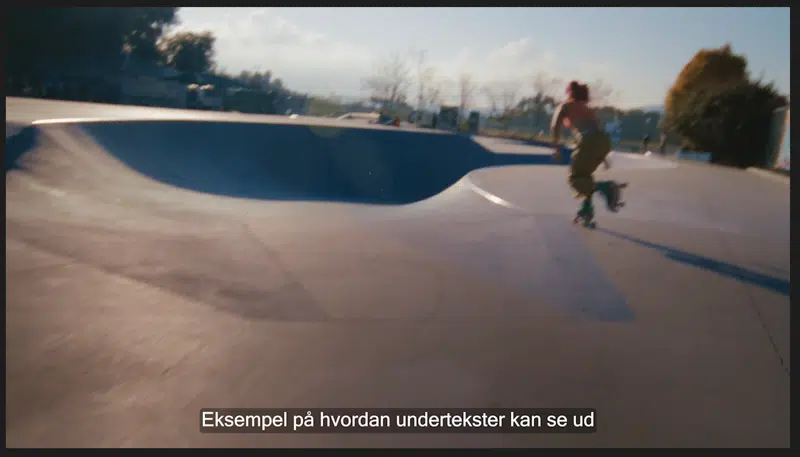 Et eksempel på, hvordan brændte undertekster, der følger anbefalingerne for placering, font, tekstfarve, baggrund og maks. bredde i Premiere Pro, ser ud, når de er indsat nederst i videobilledet og ikke fylder mere end 80 procent af videobredden..  