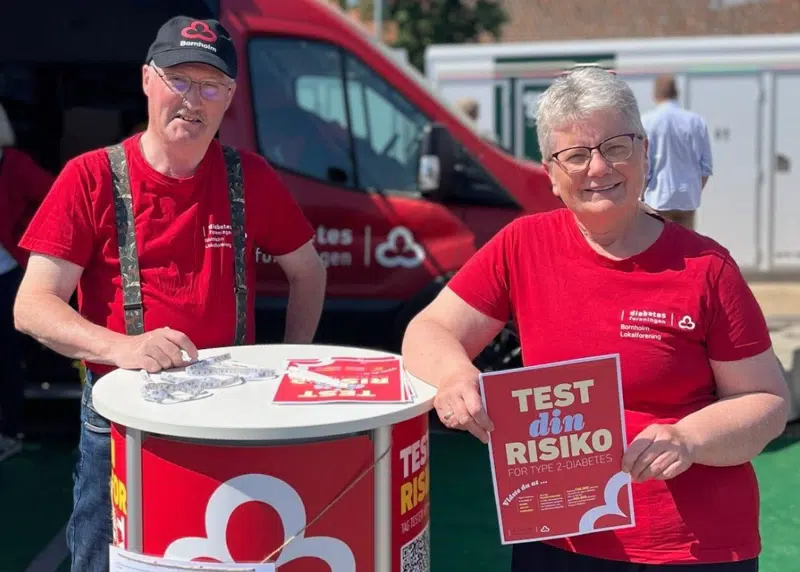 To personer fra Diabetesforeningen står foran den røde sundhedsbus og tilbyder en test for type 2-diabetes.