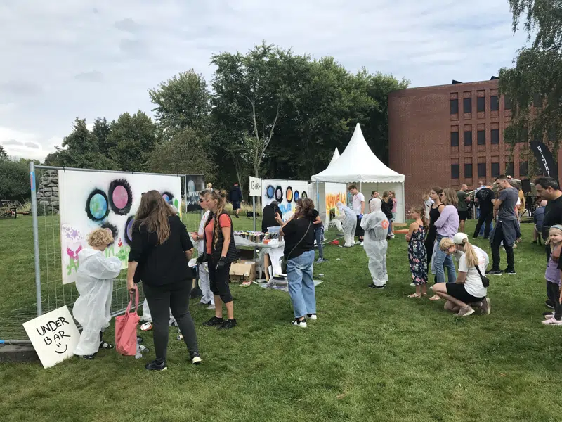 Unge gladsaxeborgere maler graffiti på hvide lærreder uden for Gladsaxe Rådhus på Gladsaxedagen 2024. 