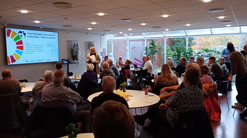 De fremmødte sidder i Rådhuskælderen og ser på en oplægsholder.