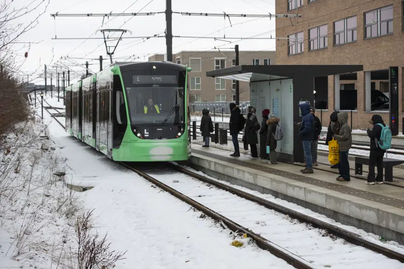Letbanetog i snevejr ved Glostrup Station - passagerer står af og på.