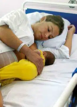Liggende ammestilling, hvor mor ligger på siden og barnet ligger på siden, med ansigtet ind mod det nederste bryst