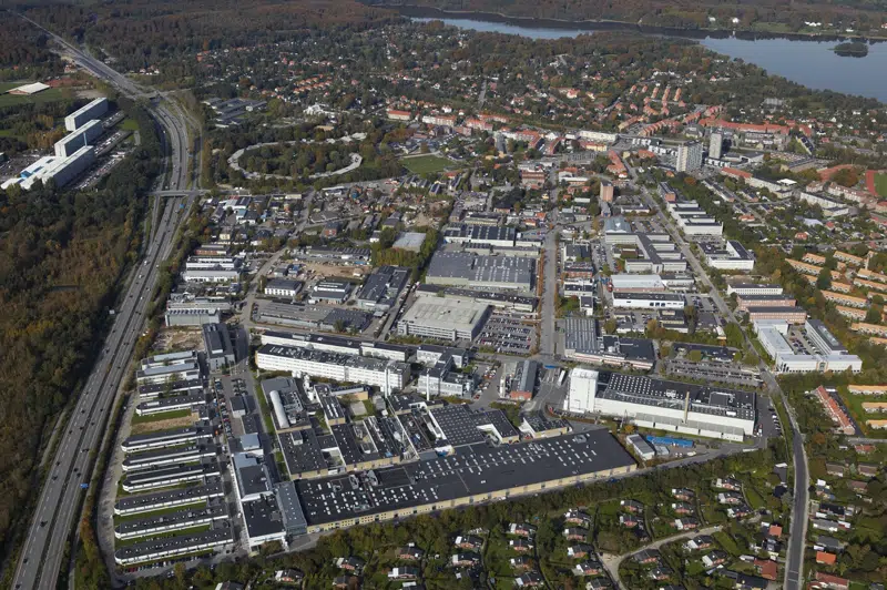 Et luftfoto af Gladsaxe med efterårsfarver og Bagsværd Sø i baggrunden.