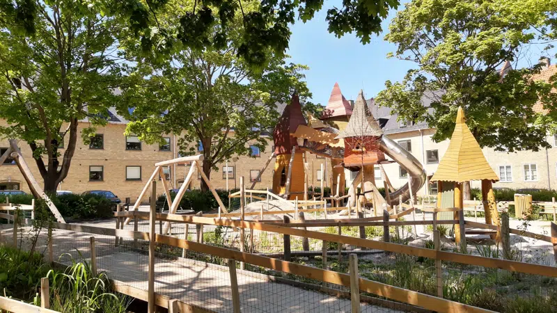 Stor legeplads i naturmateriale med høje tårne og rutchebane