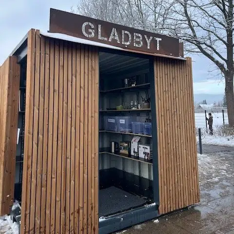 Et billede af byttecontaineren med skiltet "GLADBYT" for oven.