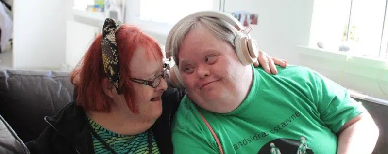 To borgere sidder tæt sammen og smiler til hinanden