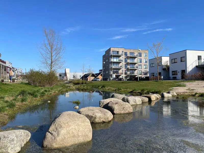 Det grønne stiforløb med vandløb snor sig forbi bebyggelserne i bydelen Nærheden.