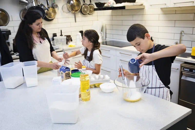 Pædagog laver kage med to medlemer fra FK