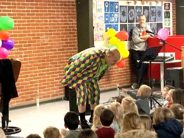 Lærer i farverigt tøj tryller for børnene