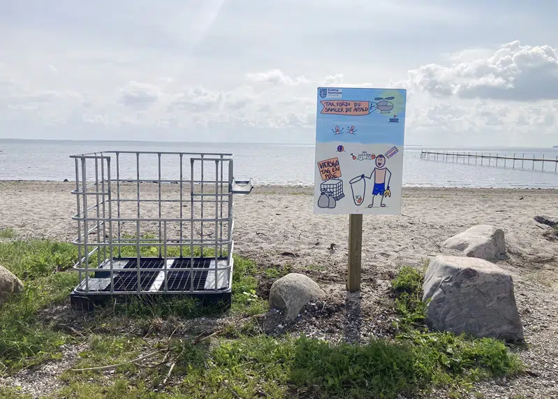 Affaldsskilt og palleramme på strand