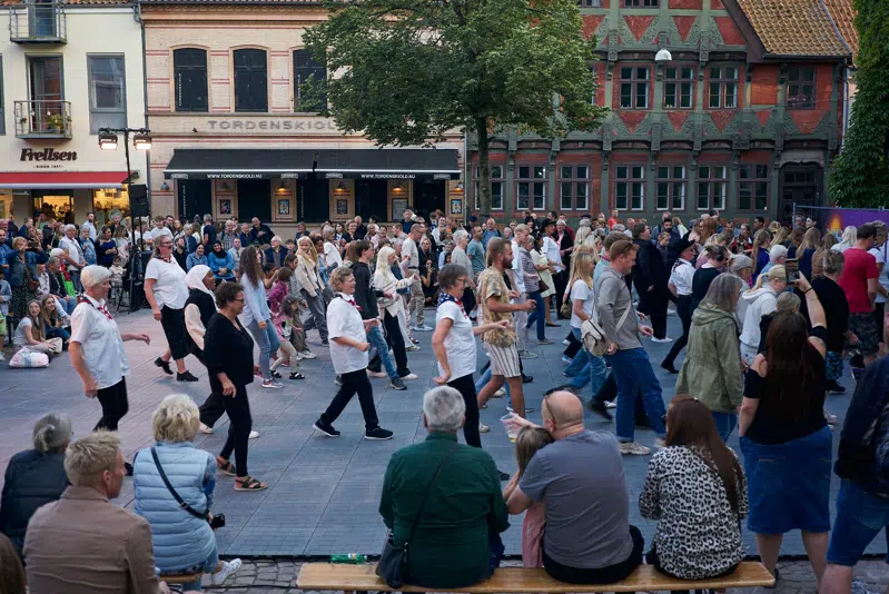 mange mennesker i alle aldre deltager i fællesdans på dansegulvet på Akseltorv