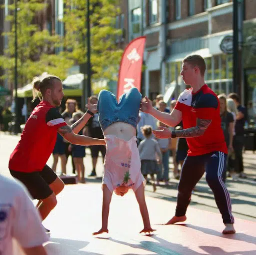 To hjælpere guider en person til at lave en flikflak