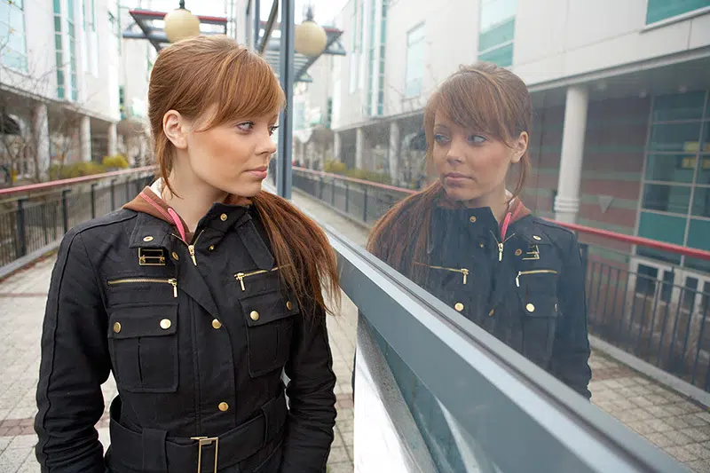 Kvinde spejler sig i rude