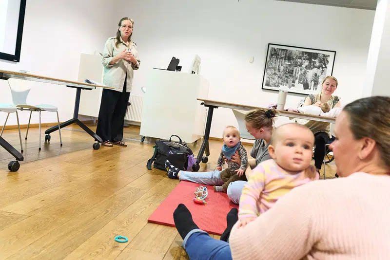 mødre sidder på gulvet med babyer