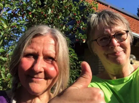 To damer der smiler og giver tommel op