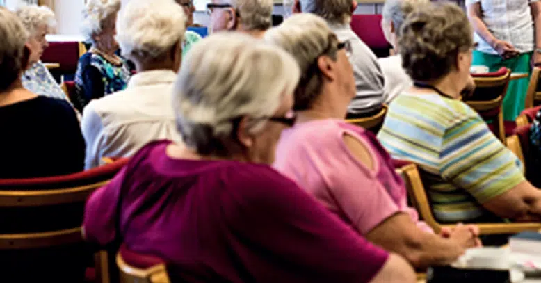Ældre mennesker der sidder og lytter