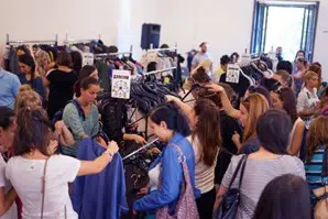 Mange mennesker i et rum. De køber genbrugstøj