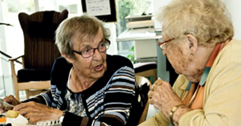 To damer der sidder og snakker sammen