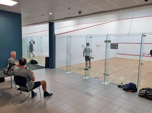 Squashbaner, hvor nogen træner og andre sidder og kigger