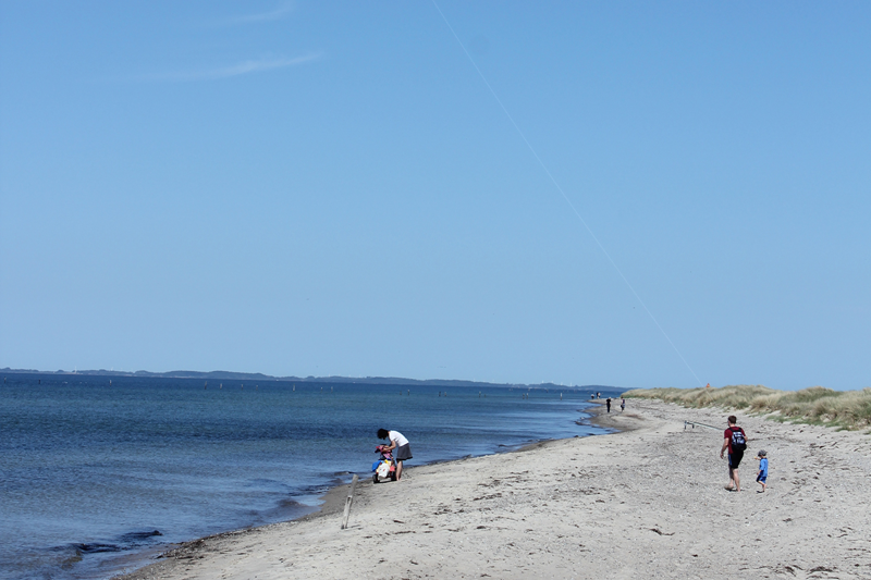 Albuen Strand med mennesker på stranden og blå himmel