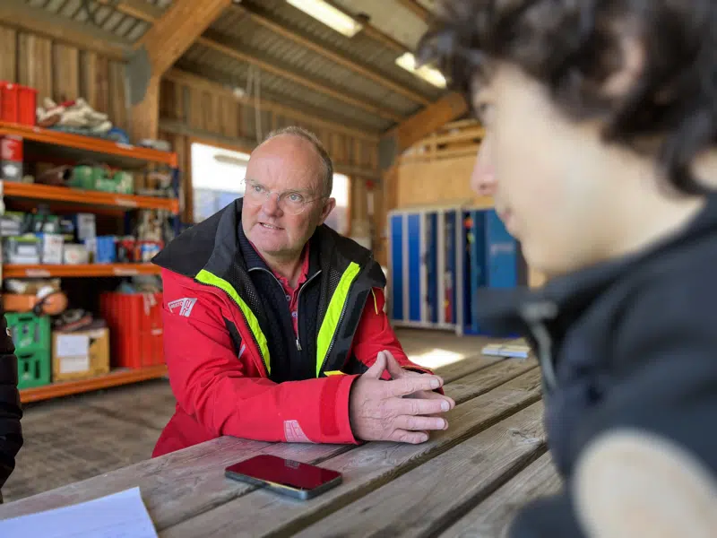 en mand, der sidder ved et bord i en eksamenssituation