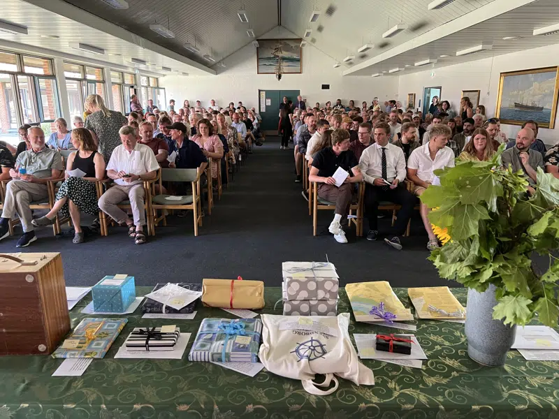 En gruppe mennesker, der sidder i en festsal