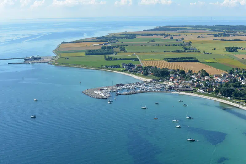 luftbillede af Ballen havn fra vandsiden. Hav, strand, havn. Marker i bagrunden og både i vandet.