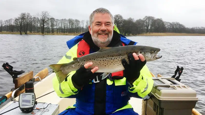 Lystfisker, der har fanget en stor søørrred fra båd